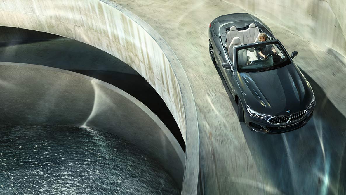 BMW M850i xDrive с опущенным мягким верхом, в движении, вид с высоты птичьего полета. BMW M850i xDrive с опущенным мягким верхом, в движении, вид с высоты птичьего полета.
